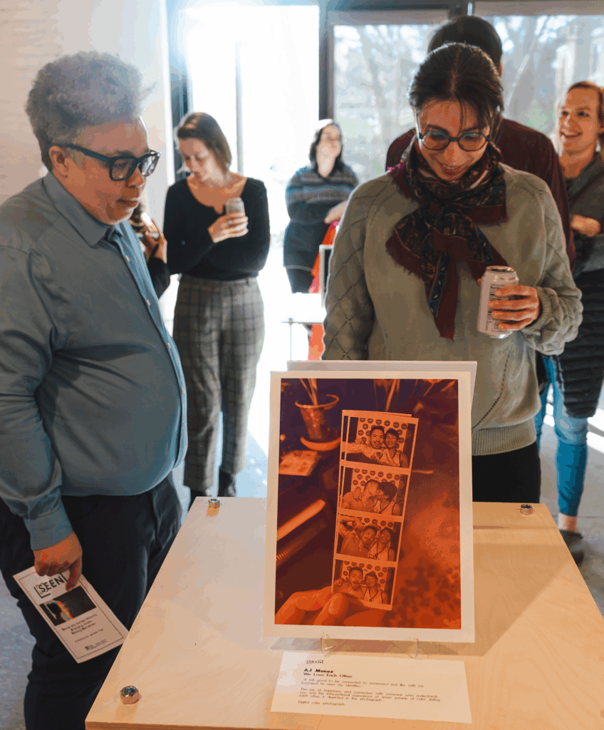 A photo of diverse people gathered around art on display