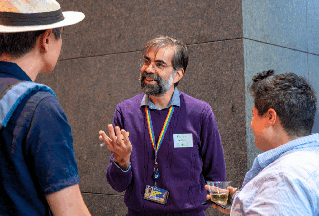 Photo of Eidos Director of Engagement Kevin Schott speaking to two people to his left and right.