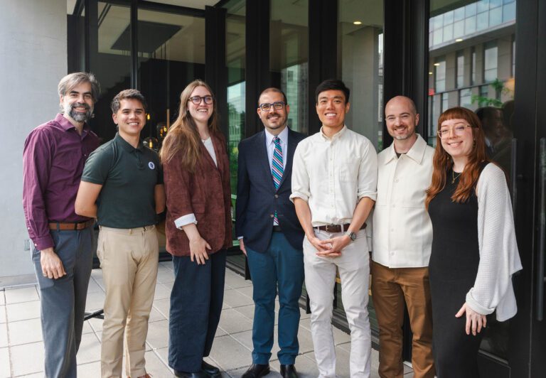 A photograph of 7 people from the Eidos team standing together and smiling